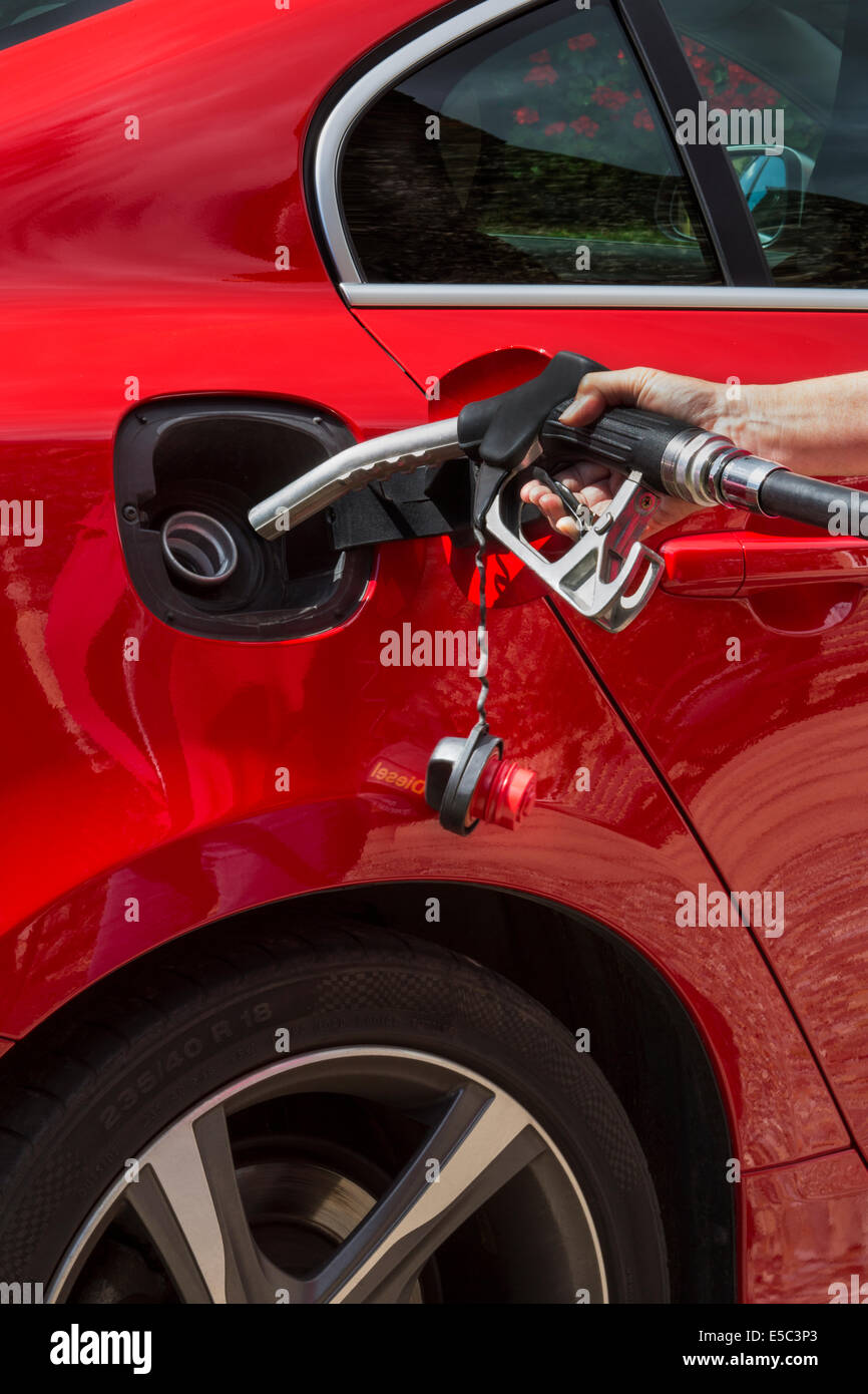 Il pompaggio del gas - riempimento di un auto il serbatoio del combustibile con gasolio o petrolio. Foto Stock