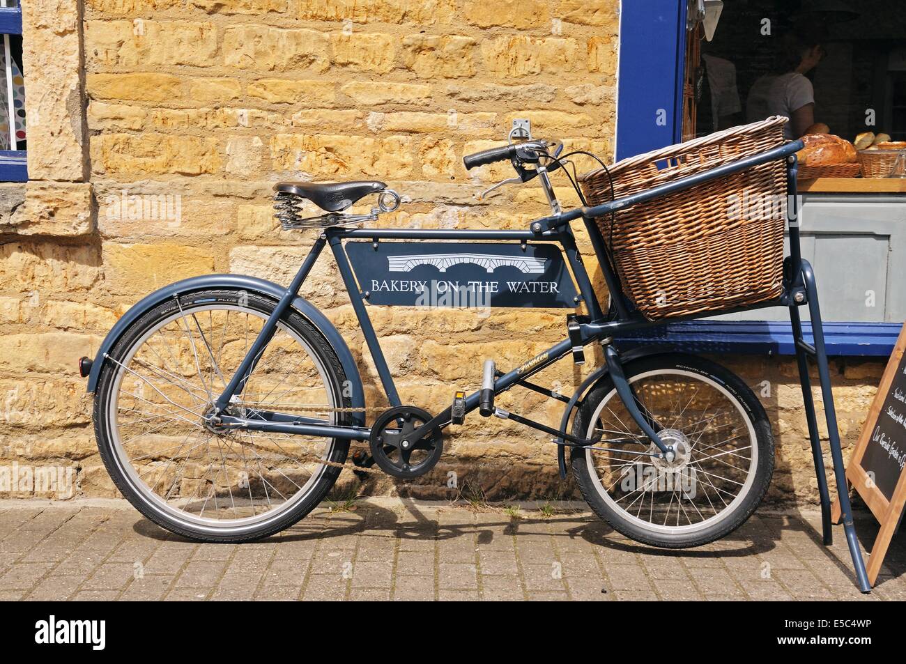 Pasticceria al segno d'acqua su un negozio di generi alimentari noleggio al di fuori del negozio di pane nel villaggio, Bourton sull'acqua, Inghilterra, Regno Unito. Foto Stock