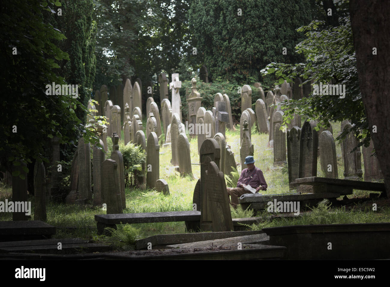 Gentleman tenendo il pranzo su una lapide nel cimitero di Bronte la chiesa di San Michele e tutti gli angeli in Haworth Yorkshire Foto Stock