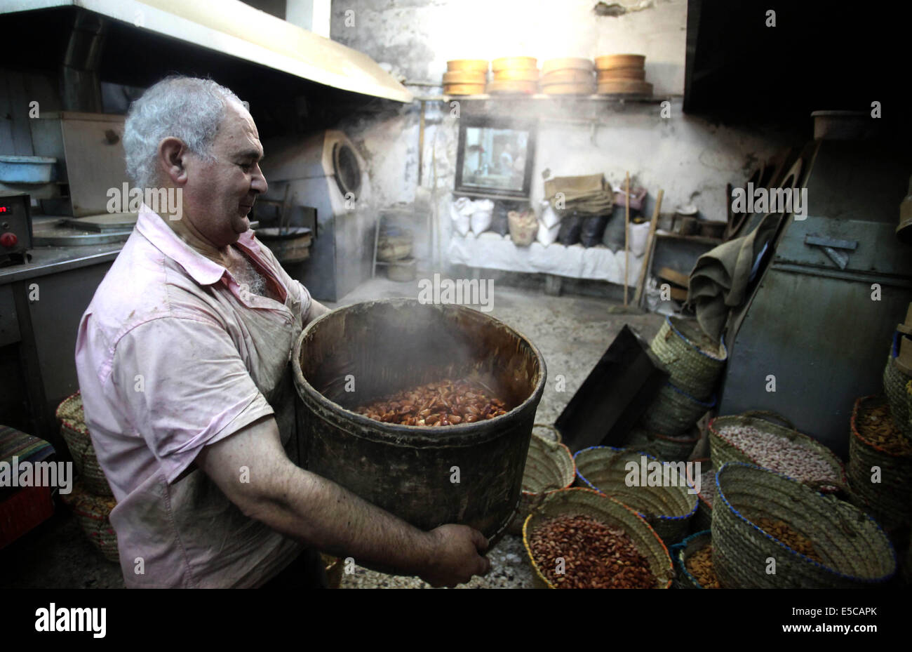 Luglio 27, 2014 - Gerusalemme, Gerusalemme, Territorio palestinese - un uomo palestinese prepara i dadi per la preparazione per la prossima Eid al-Fitr festival, in un mercato di Gerusalemme il 27 luglio 2014. Eid al-Fitr festival è accolto come un triste Eid tra palestinesi da parte delle forze israeliane rinnovato è incursioni su Gaza, che a seguito di una 24 ore di tregua, uccisi nove palestinesi, sollevando il pedaggio complessivo da 20 giorni di funzionamento per più di 1.050. Sami Abu Zuhri senior portavoce per l'organizzazione palestinese Hamas ha detto a detto, ''In risposta a un intervento delle Nazioni Unite e tenendo conto della situazione del nostro popolo e th Foto Stock