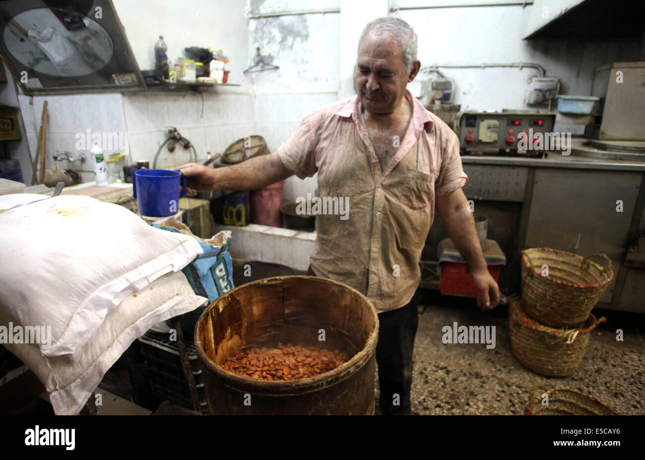 Luglio 27, 2014 - Gerusalemme, Gerusalemme, Territorio palestinese - un uomo palestinese prepara i dadi per la preparazione per la prossima Eid al-Fitr festival, in un mercato di Gerusalemme il 27 luglio 2014. Eid al-Fitr festival è accolto come un triste Eid tra palestinesi da parte delle forze israeliane rinnovato è incursioni su Gaza, che a seguito di una 24 ore di tregua, uccisi nove palestinesi, sollevando il pedaggio complessivo da 20 giorni di funzionamento per più di 1.050. Sami Abu Zuhri senior portavoce per l'organizzazione palestinese Hamas ha detto a detto, ''In risposta a un intervento delle Nazioni Unite e tenendo conto della situazione del nostro popolo e th Foto Stock