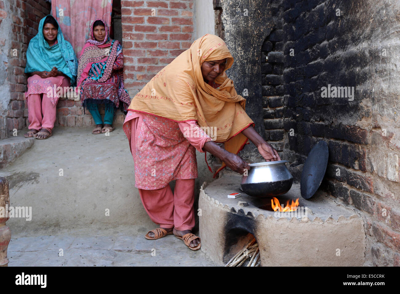 Donna pakistana in un tradizionale camino al di fuori di una casa a Lahore, in Pakistan. Foto Stock
