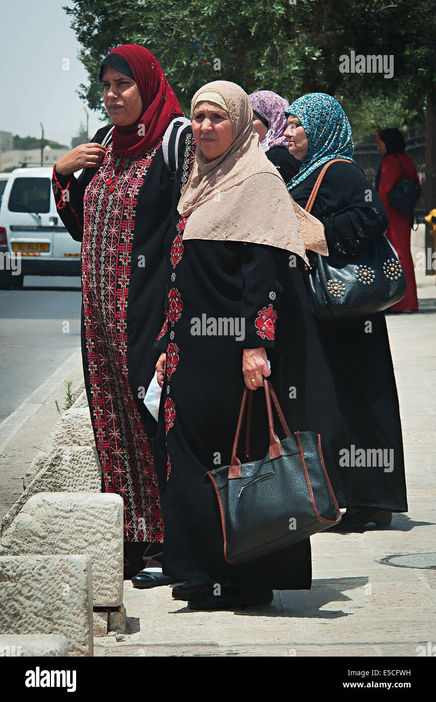 Arabo le donne israeliane attende un bus fuori dalla città vecchia di Gerusalemme, Israele Foto Stock