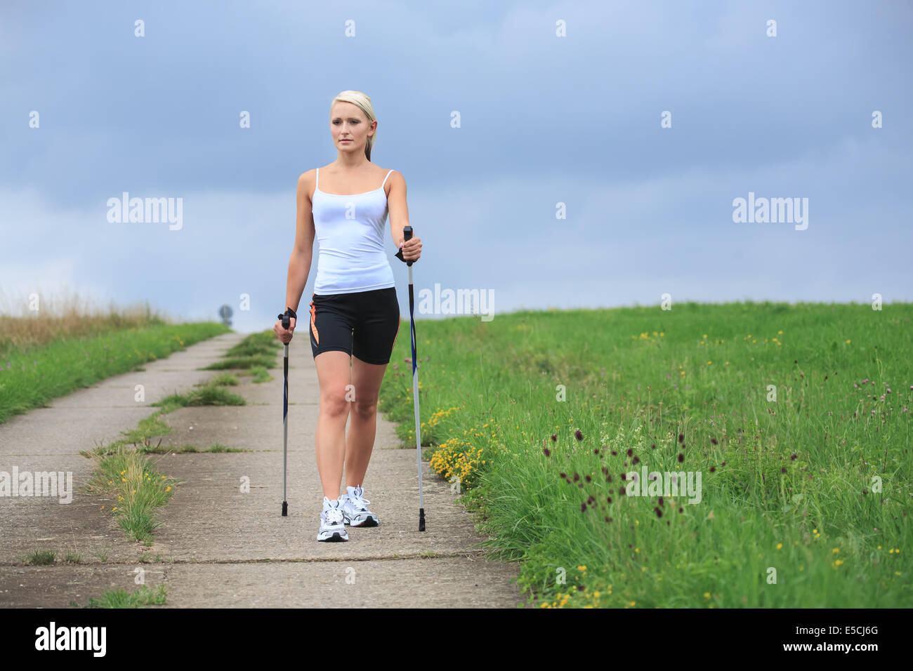 Una giovane donna fare nordic walking. outdoor shoot. Foto Stock