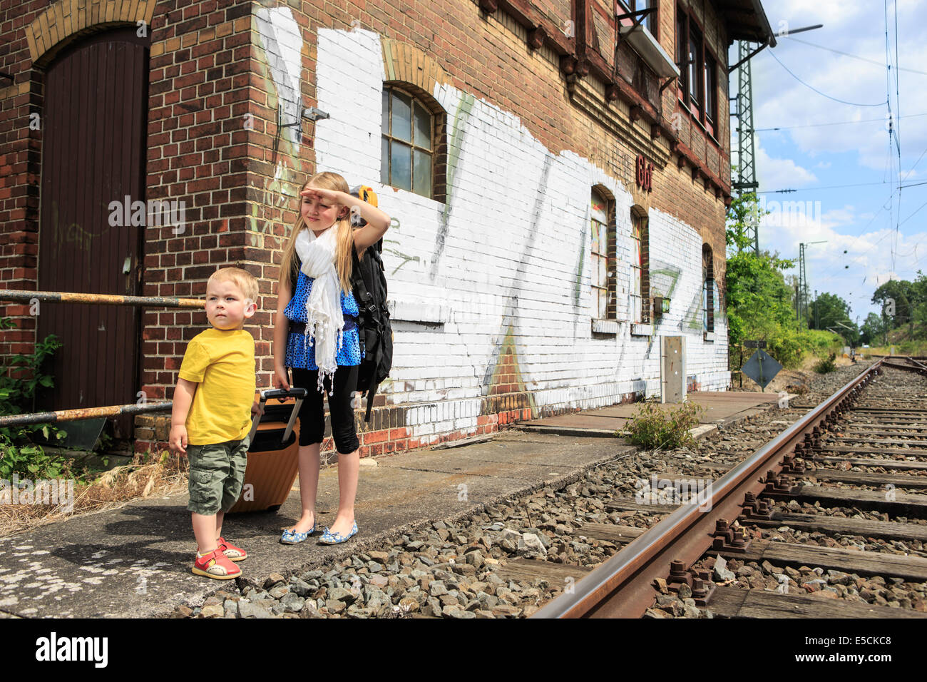 I bambini in attesa per il treno in una stazione ferroviaria Foto Stock