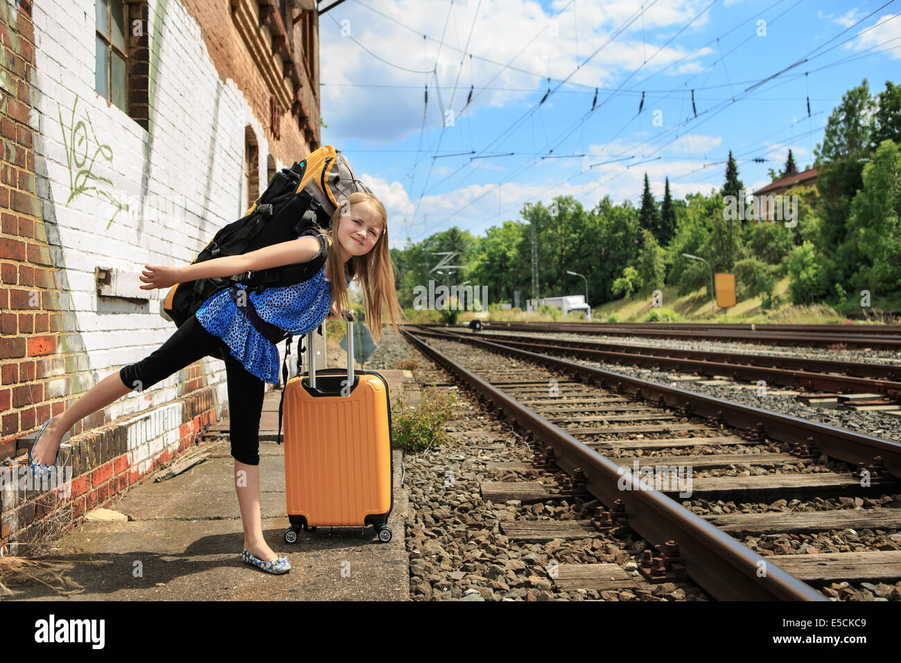 Ragazza di attesa per il treno sulla stazione ferroviaria Foto Stock