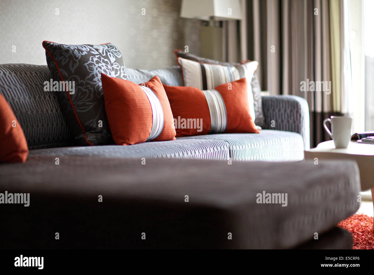 Cuscini di colore arancione sul divano ad angolo in casa britannica Foto  stock - Alamy