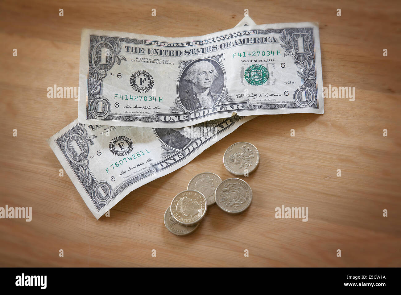 American le fatture del dollaro e la sterlina britannica monete su un tavolo. Foto Stock