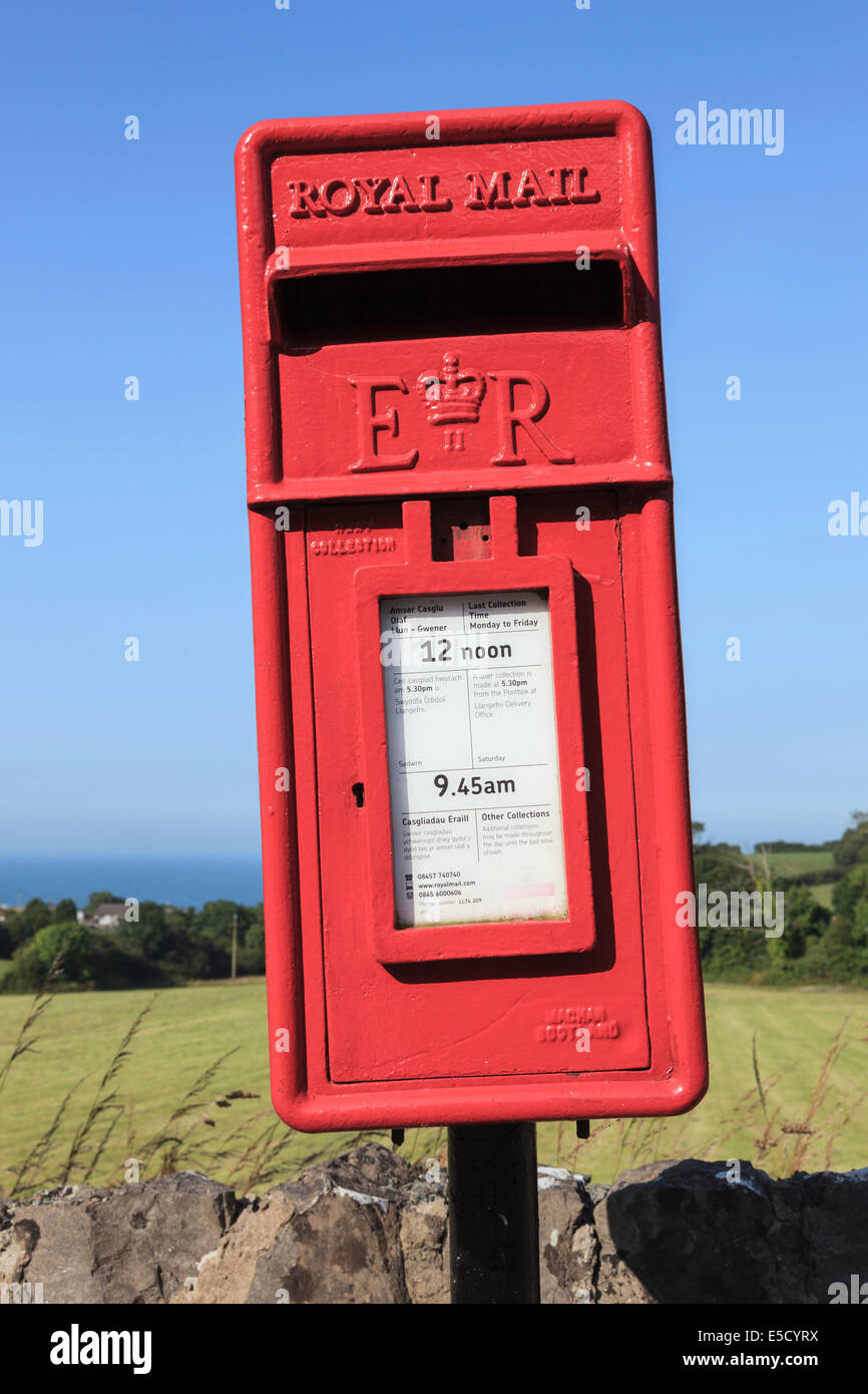 Dipinto recentemente rosso wonky Royal Mail postbox proteso lateralmente contro il cielo blu. Regno Unito Foto Stock