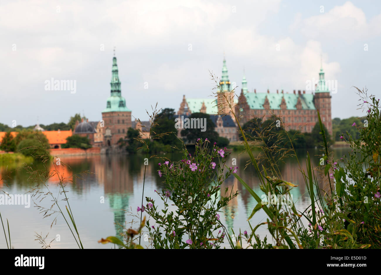 Castello di Frederiksborg a Hillerød, in Nord Zelanda, Danimarca, visto dall'altra riva del lago del castello. Grande willow-erba in fuoco. Foto Stock