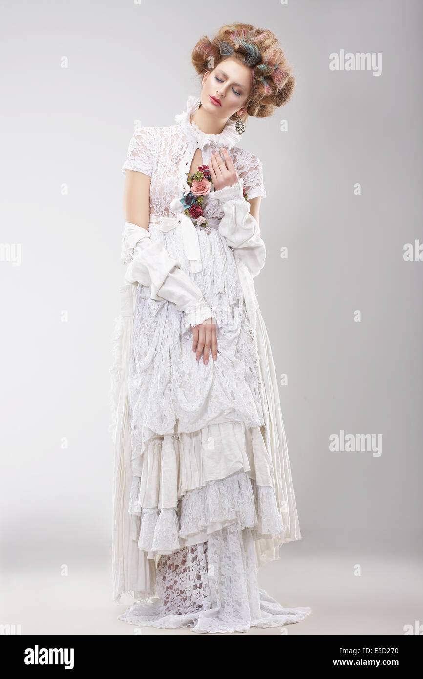 Splendida Outre femmina in Lacy abito bianco con fiori Foto Stock