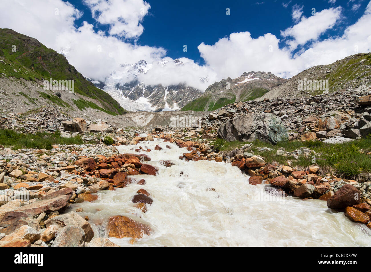 Il torrente a valle Enguri proveniente dal ghiacciaio Shkhara e massiccio, a 5068 m e la vetta più alta in Georgia. Foto Stock