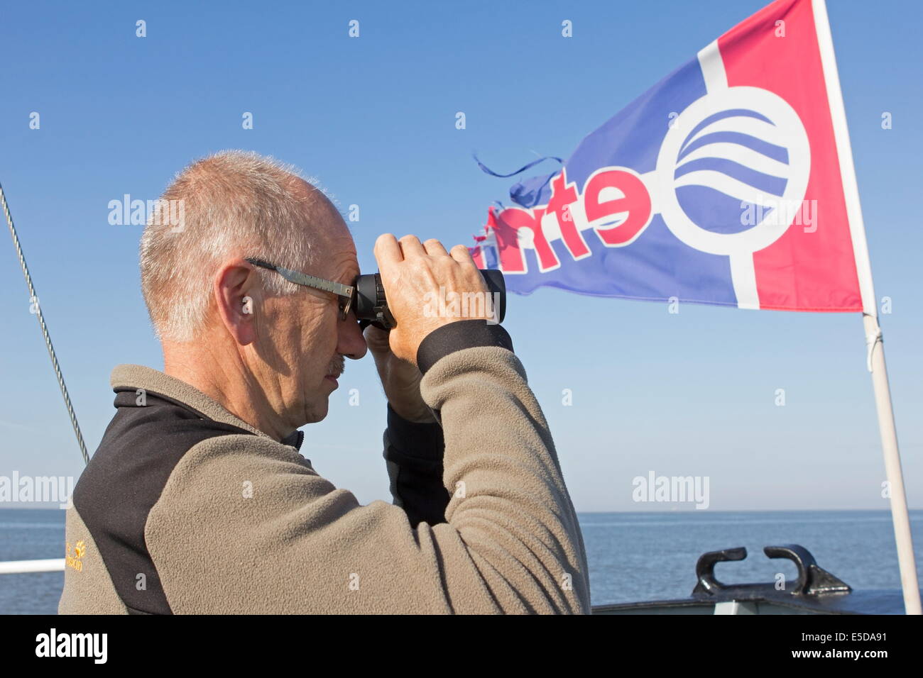 Dipendente con il binocolo nave che naviga a Natuurmonumenten Griend, Paesi Bassi Foto Stock