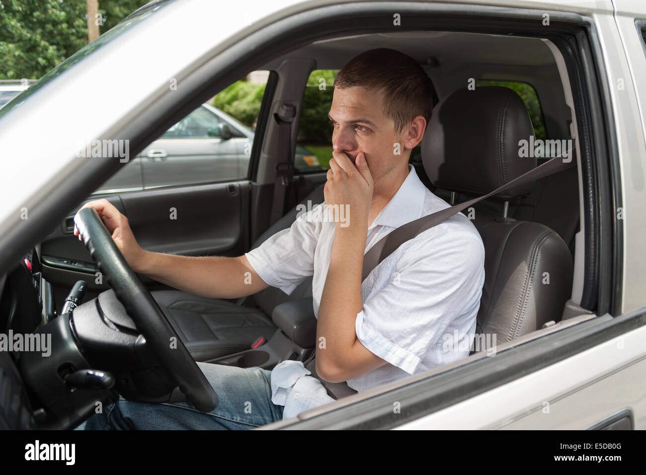 I giovani europei driver è scioccata e tenendo la sua mano sulla sua bocca Foto Stock