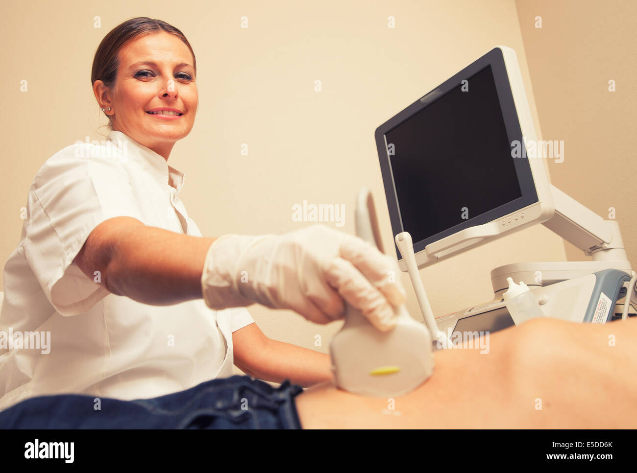 Donna felice medico analisi paziente di sesso maschile con addome ultrasuoni. Foto Stock
