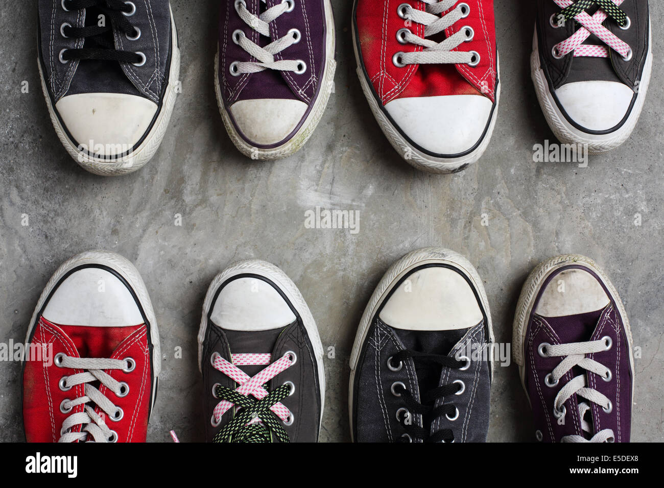 Due righe di Converse scarpe, punta a punta, sparato contro un sfondo di  calcestruzzo Foto stock - Alamy