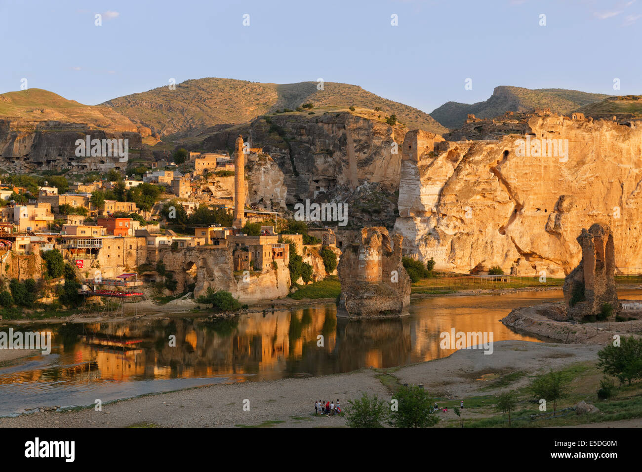 Veduta del paese con il minareto della El Rizk moschea, pilastri del ponte costruito dal Ortocides, Hasankeyf, Tigris River Foto Stock