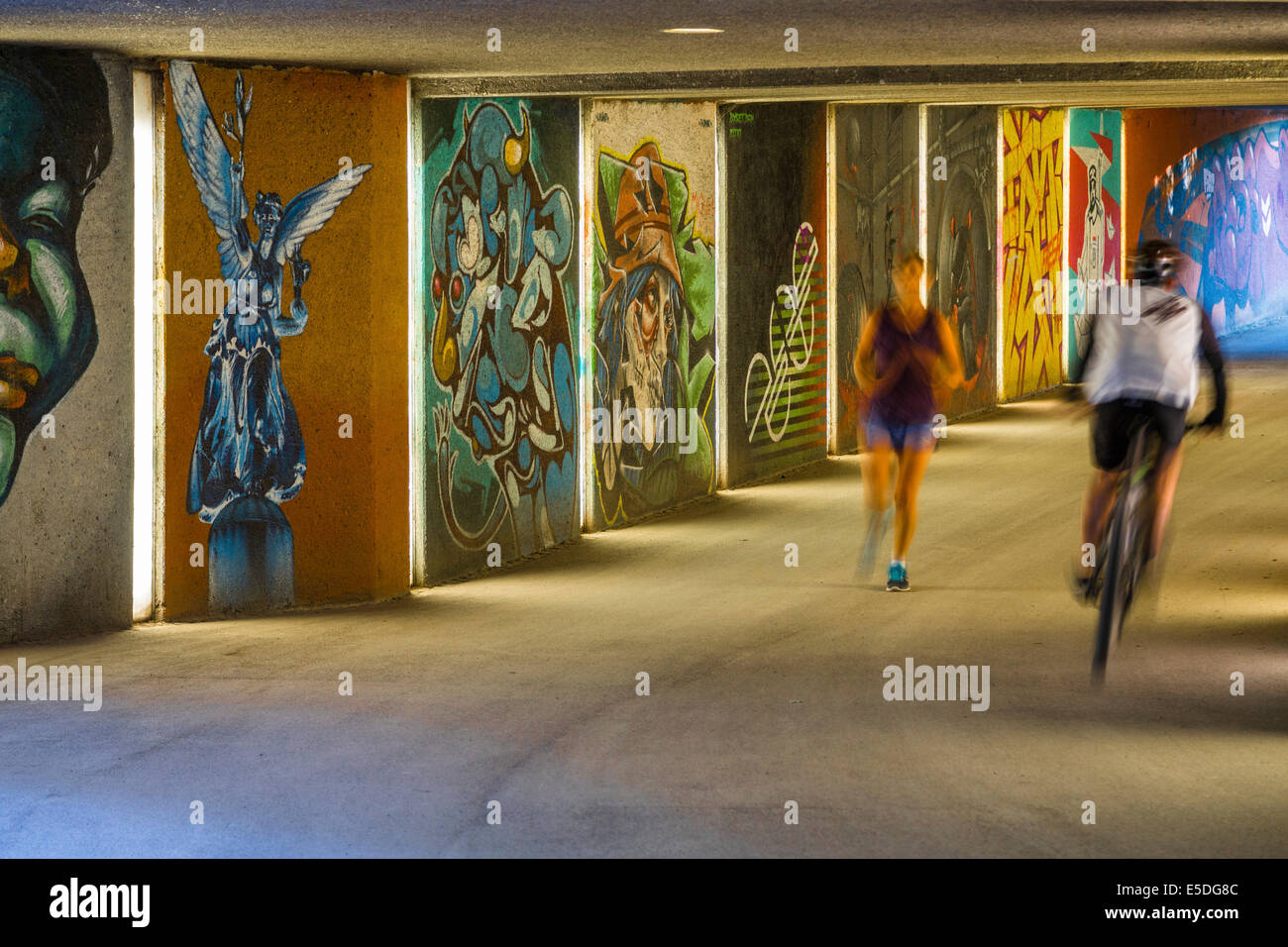 Sottopassaggio pedonale con graffiti arte, con un ciclista e un pareggiatore, Massimiliano Park, Monaco di Baviera, Baviera, Baviera, Germania Foto Stock