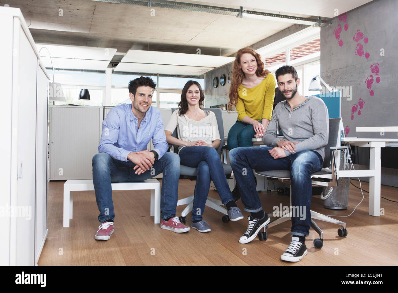 Foto di un gruppo di quattro persone creative seduto in ufficio Foto Stock