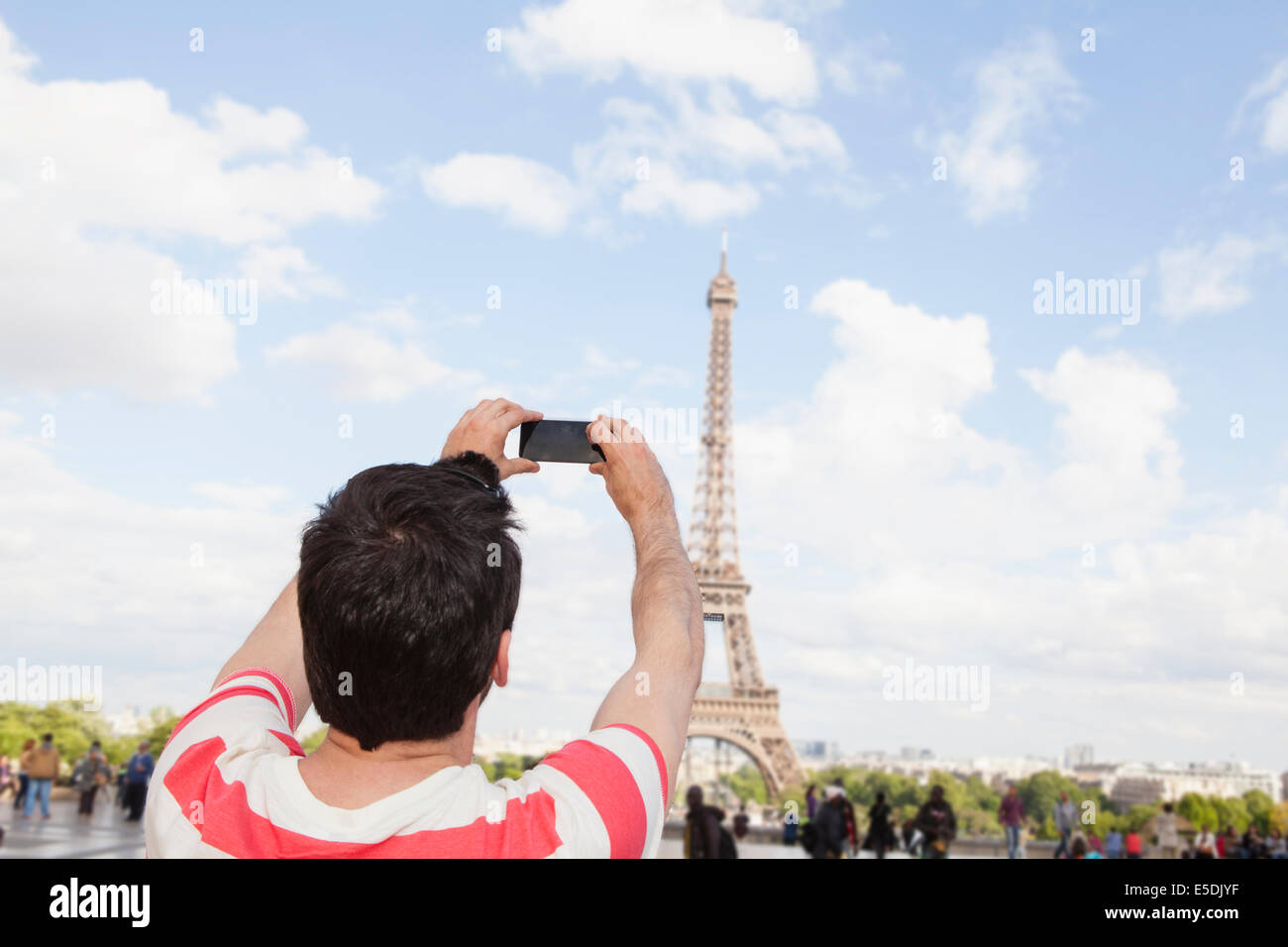 Francia, Parigi, uomo fotografare la Torre Eiffel con il suo smartphone, vista posteriore Foto Stock