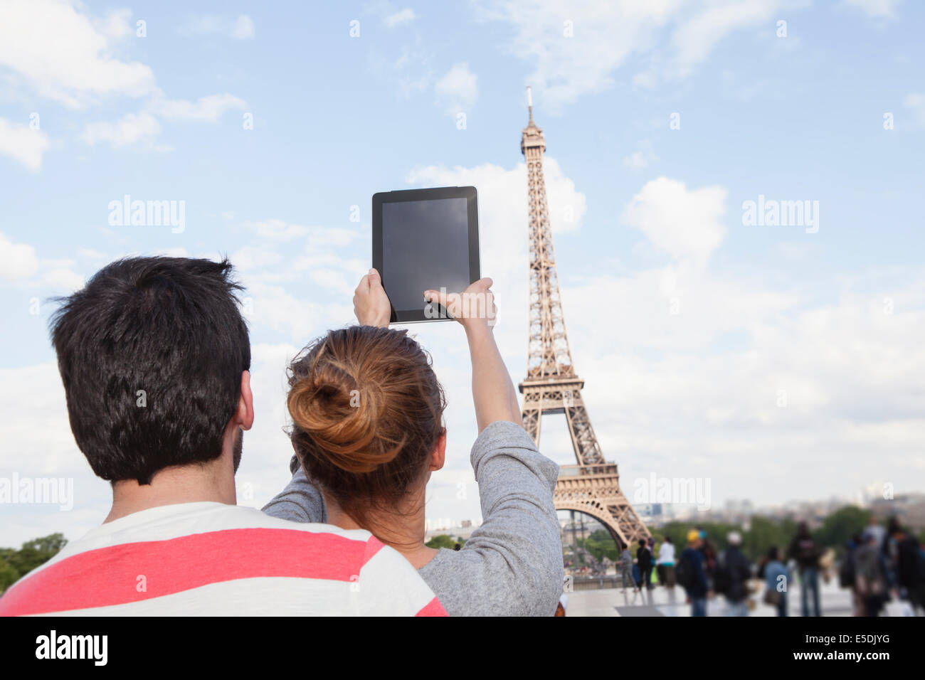 Francia, Parigi, giovane fotografare la Torre Eiffel con computer tablet, vista posteriore Foto Stock