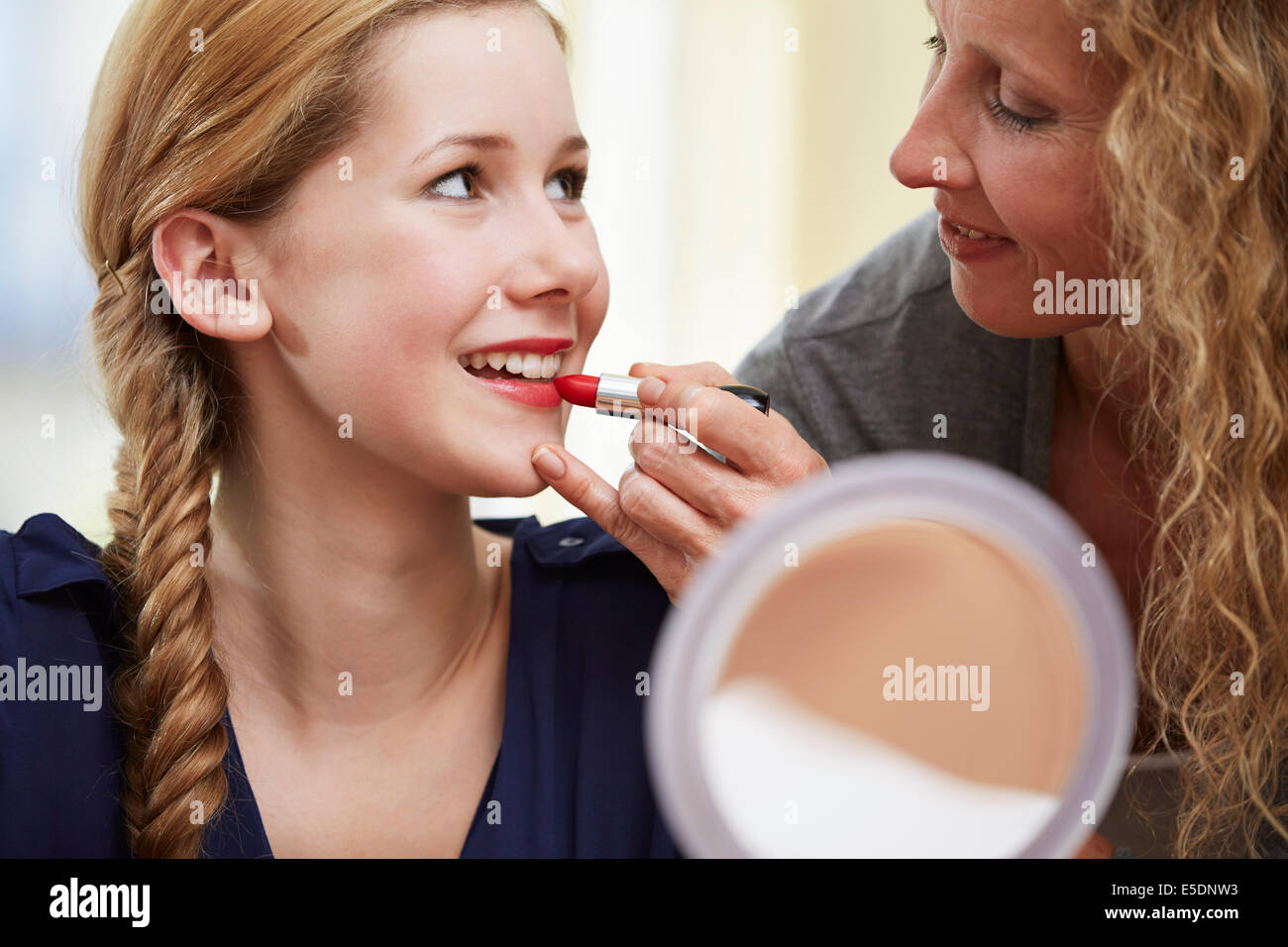 La Madre che mostra a sua figlia come usare il rossetto Foto Stock