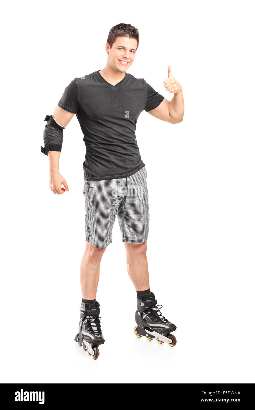 A piena lunghezza Ritratto di un uomo su pattini a rotelle dando un pollice in alto Foto Stock