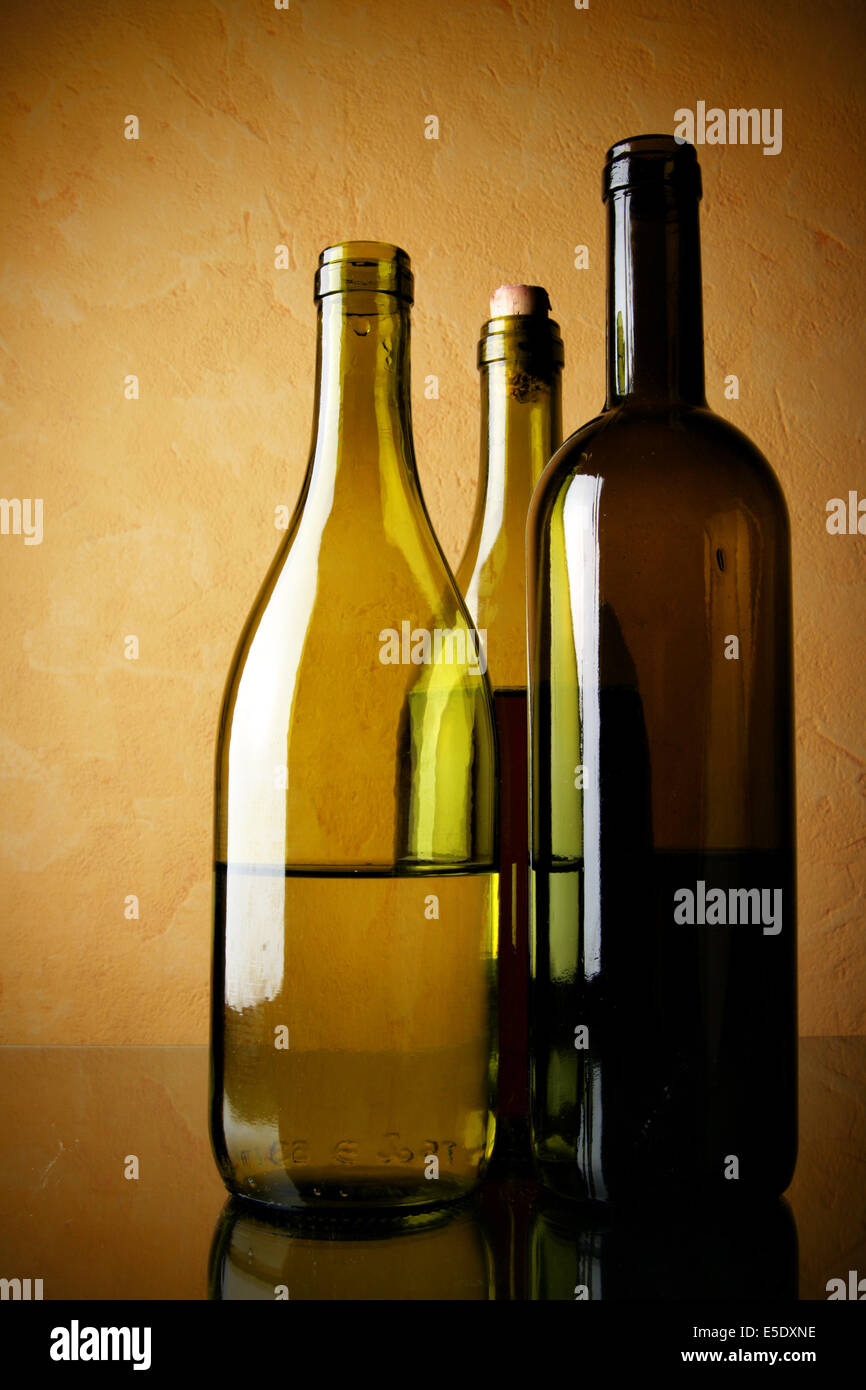 Still-life con tre bottiglie di vino su sfondo a trama Foto Stock