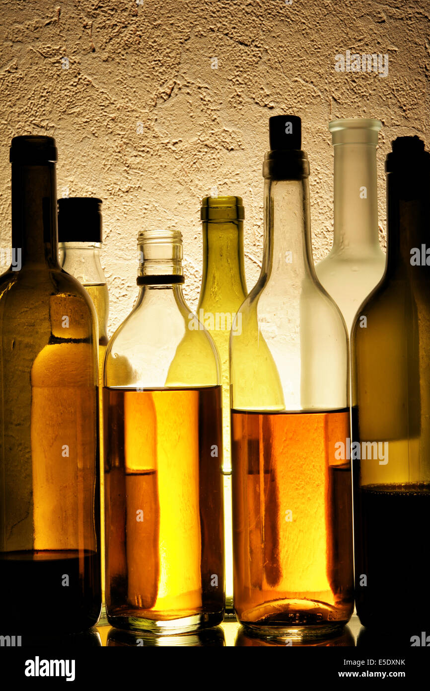 Molte bottiglie di alcolici su sfondo a trama Foto Stock