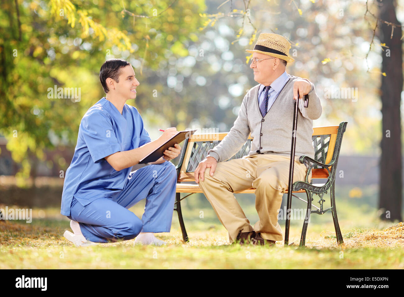 Infermiere maschio e un anziano avente una conversazione in posizione di parcheggio Foto Stock