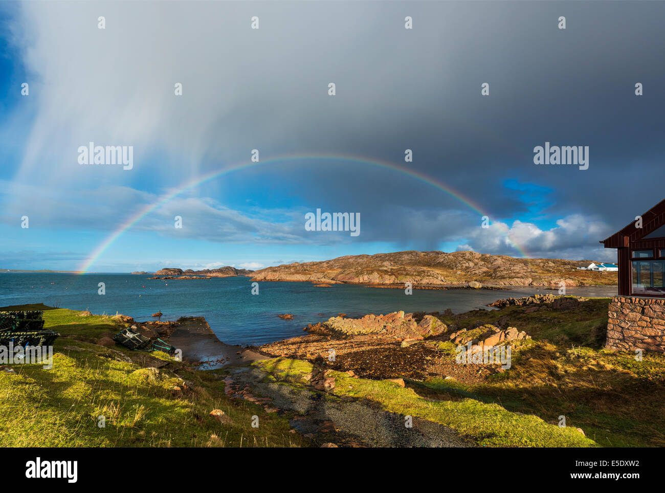 Un arcobaleno pieno attraverso il porto di Fionnphort, il principale porto del Ross di Mull Foto Stock