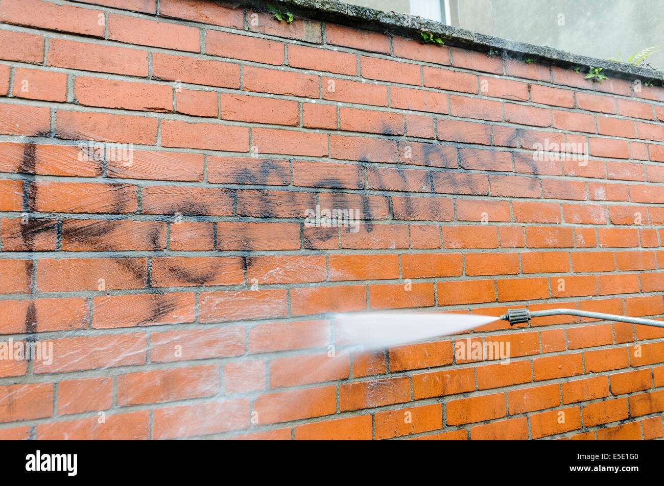 Belfast, Irlanda del Nord. 29 Luglio, 2014. Un lavoratore del consiglio rimuove graffiti dicendo "rumeni Out' spraypainted su una parete a Belfast. Credito: Stephen Barnes/Alamy Live News Foto Stock