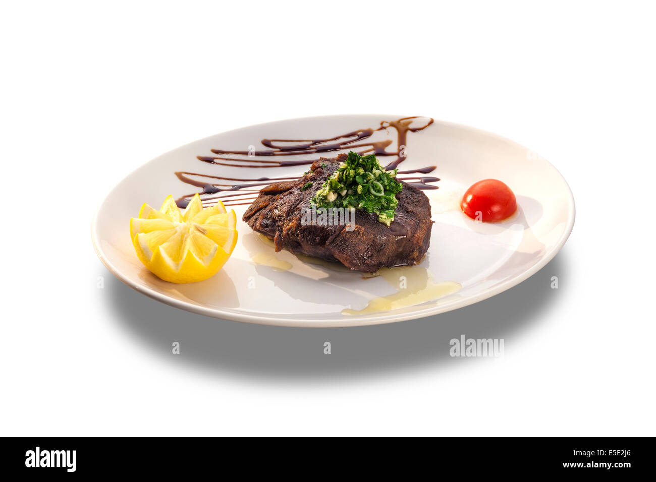 Bistecca alla griglia con limone fresco e verdure isolati su piastra bianca Foto Stock