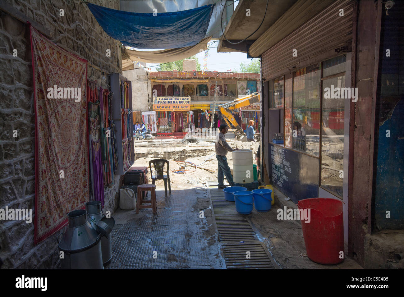Guarda un vicolo ombreggiato verso quello che un'volta era il mercato. Sono in corso lavori di ristrutturazione. Leh, Ladakh, India Foto Stock