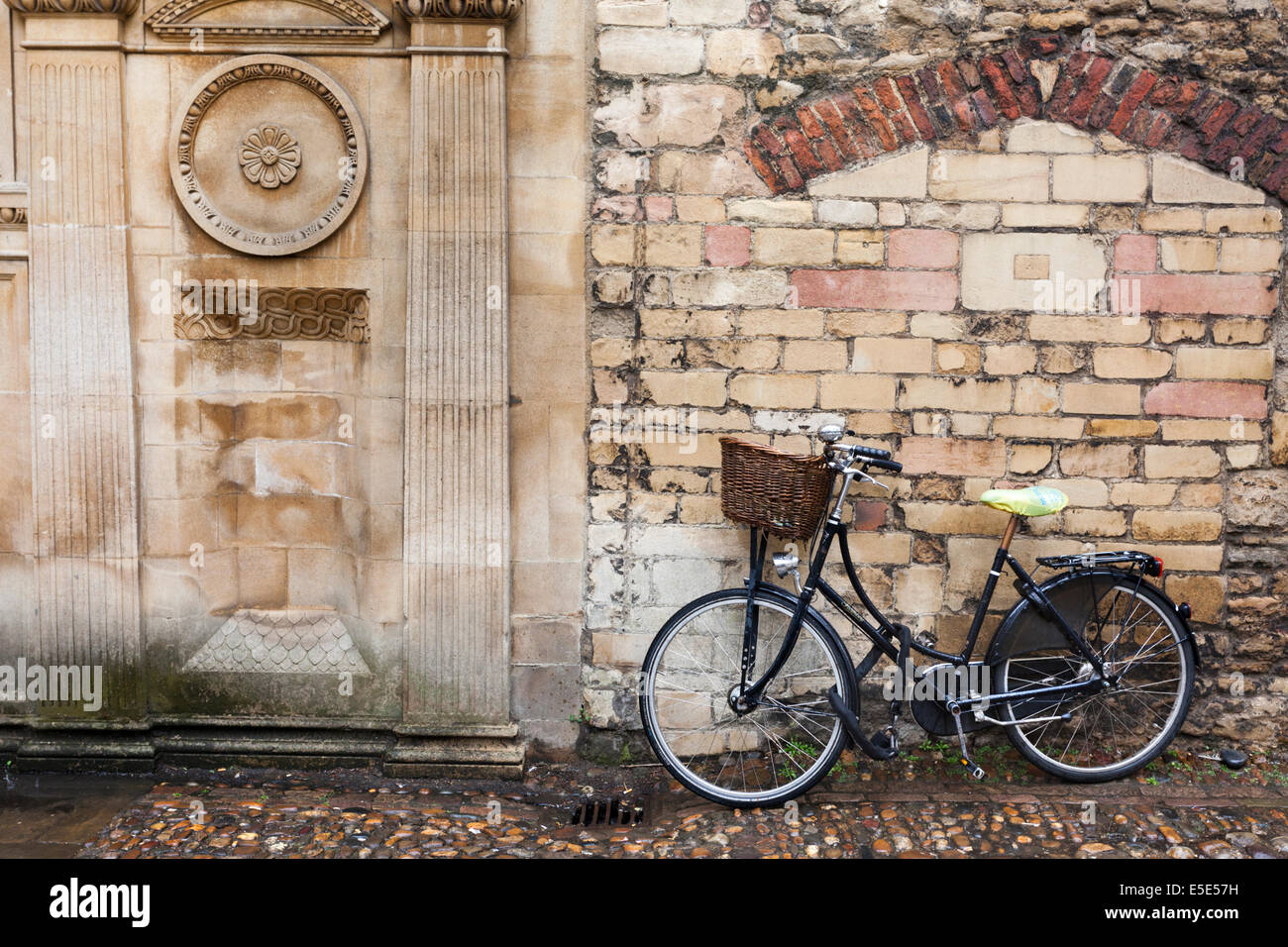 Una bicicletta parcheggiata fuori Gonville e Caius College in un giorno di pioggia nella città universitaria di Cambridge Regno Unito Foto Stock