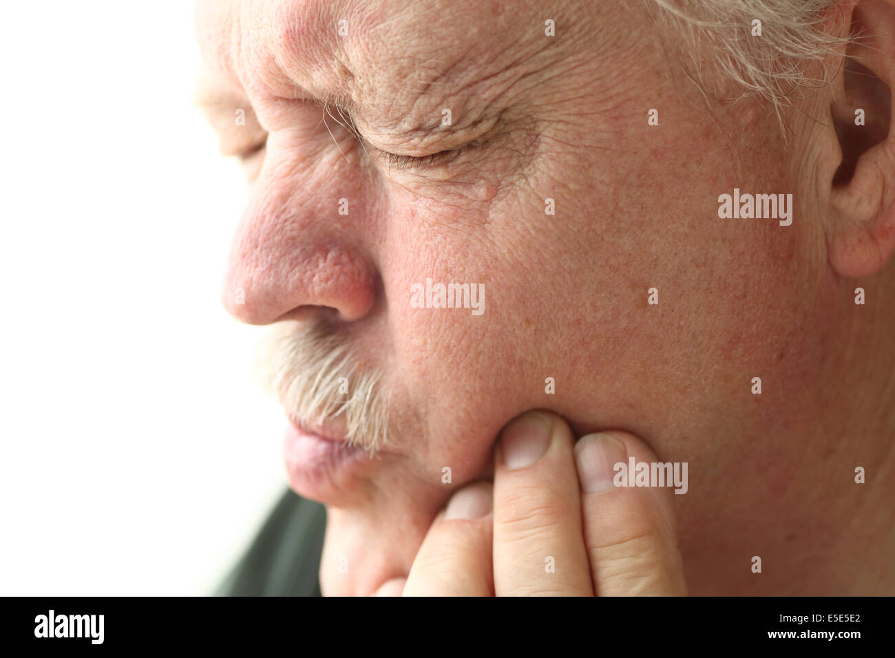 Uomo anziano sperimentando dente doloroso Foto Stock
