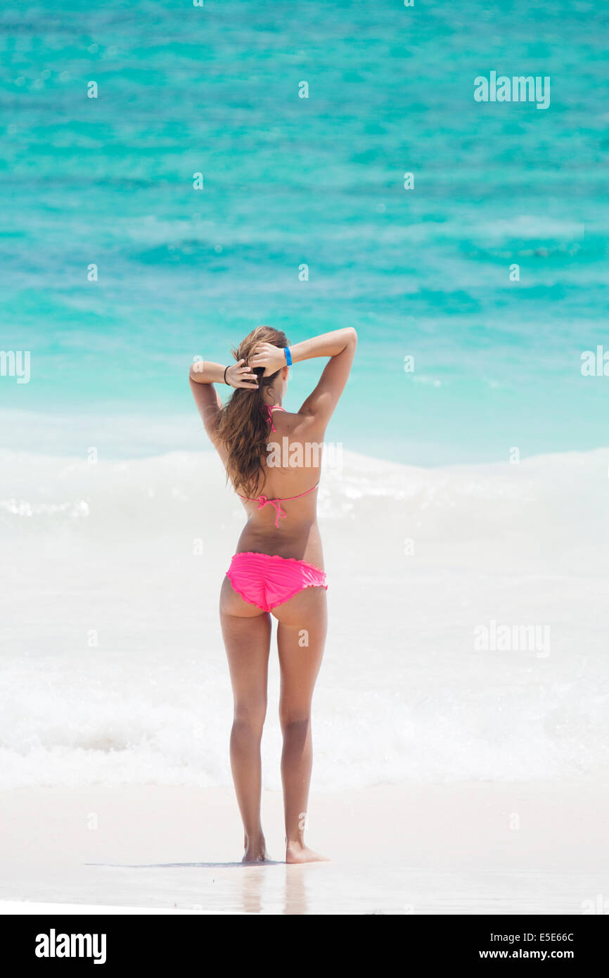 Una giovane e bella donna in bikini su una spiaggia che si affaccia sul Mare dei Caraibi Foto Stock