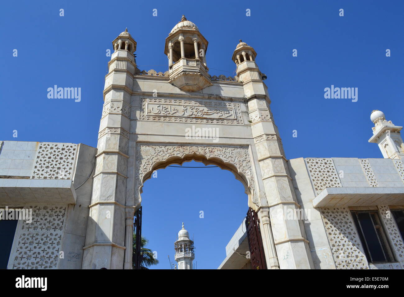 Bianco arco islamico contro un cielo blu brillante. Questo arco è all'ingresso della tomba di isola di Hajji Ali, in Mumbai Foto Stock