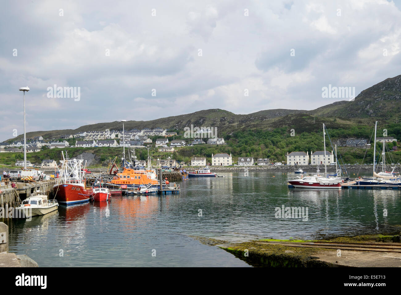 Barche e RNLI scialuppa di salvataggio ormeggiati in porto a Scottish west coast. Mallaig, Highland, Scozia, Regno Unito, Gran Bretagna Foto Stock