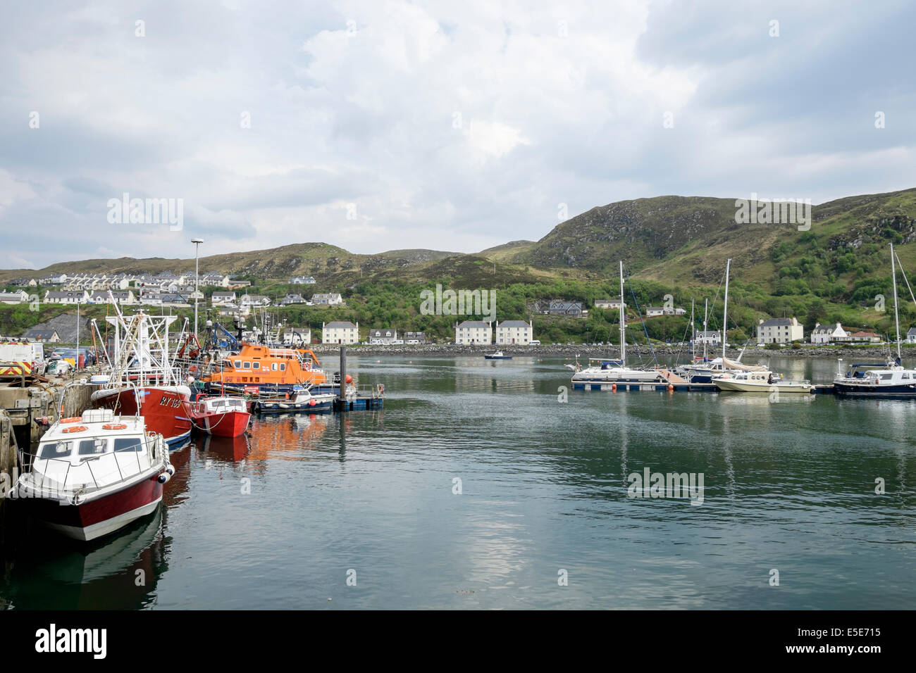 Barche e RNLI scialuppa di salvataggio ormeggiata nel porto di pescatori a Scottish west coast. Mallaig, Highland, Scozia, Regno Unito, Gran Bretagna Foto Stock