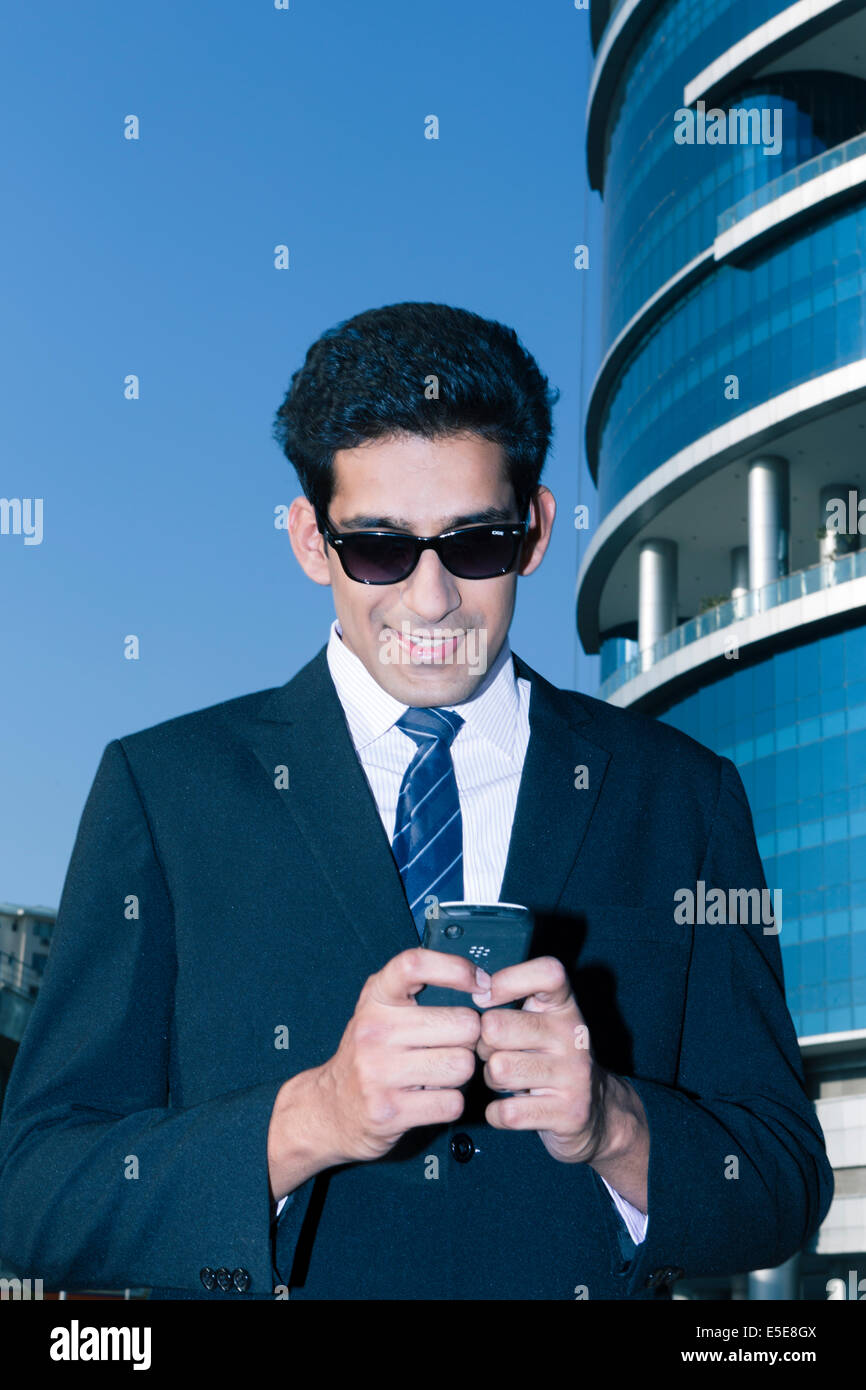 Indian business man con un telefono cellulare nel settore delle imprese di Nuova Delhi, India Foto Stock