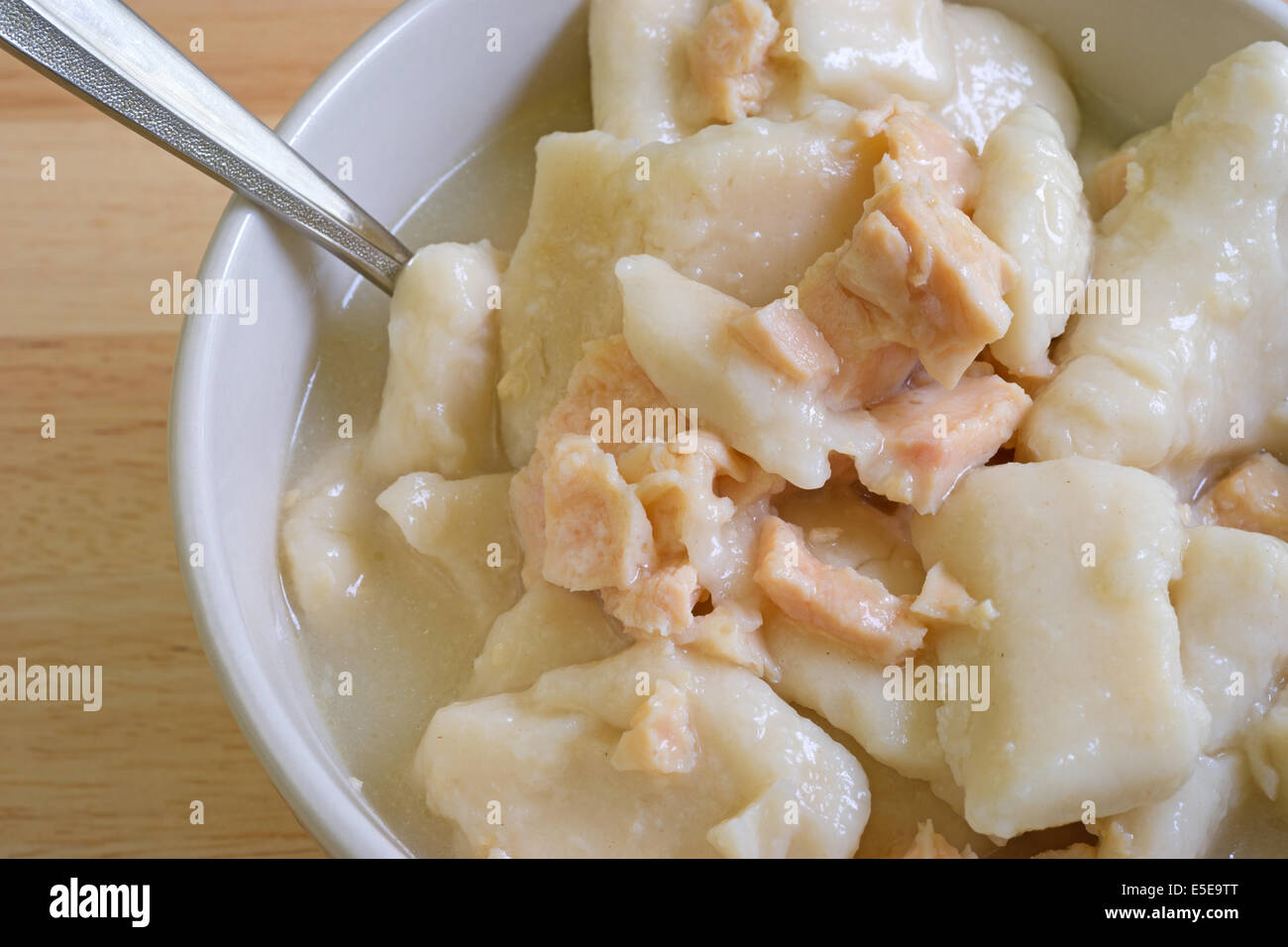 Molto vicino in vista del pollo e gnocchi di patate Zuppa in una ciotola con il cucchiaio su una tavola di legno alto. Foto Stock