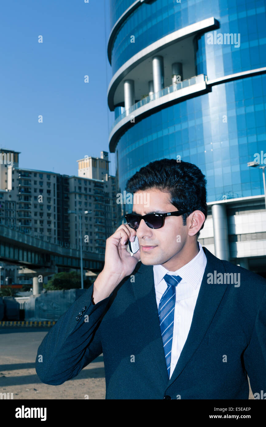 Indian business man con un telefono cellulare nel settore delle imprese di Nuova Delhi, India Foto Stock