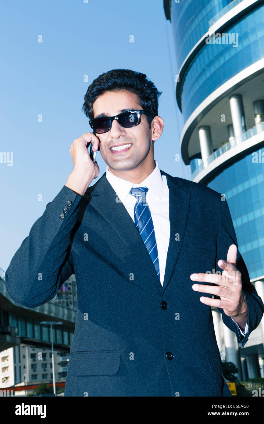 Indian business man con un telefono cellulare nel settore delle imprese di Nuova Delhi, India Foto Stock