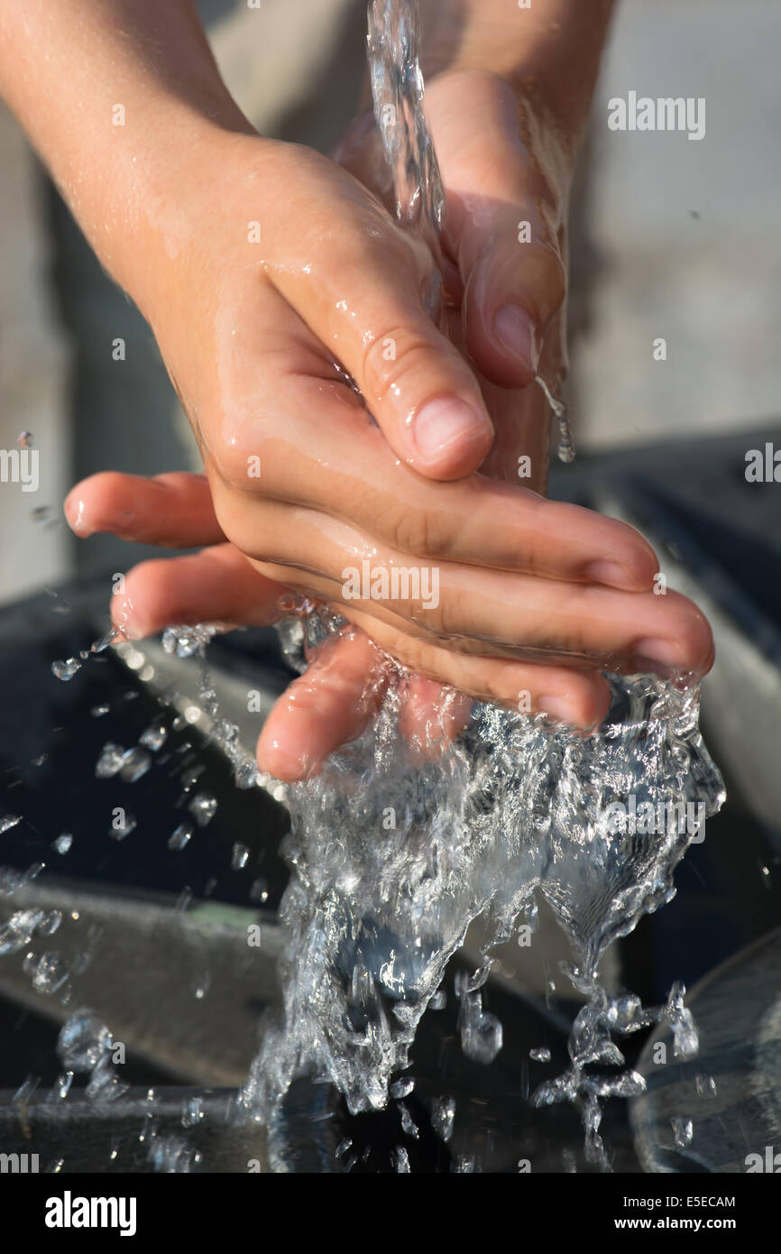 Cattura di acqua fresca e fredda e mani di pulizia sulla primavera Foto Stock