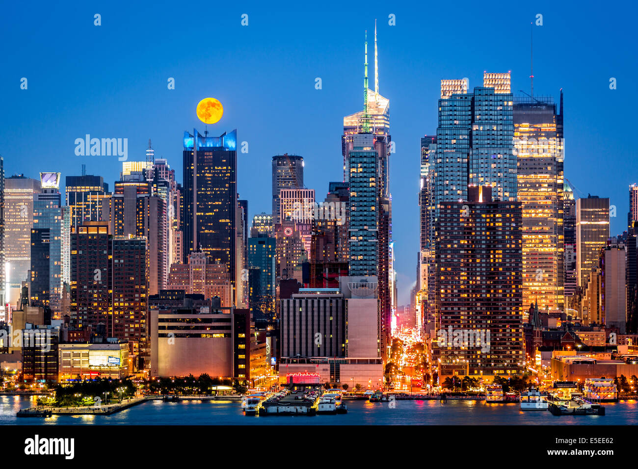 Super Luna salire al di sopra del midtown skyline di Manhattan Foto Stock