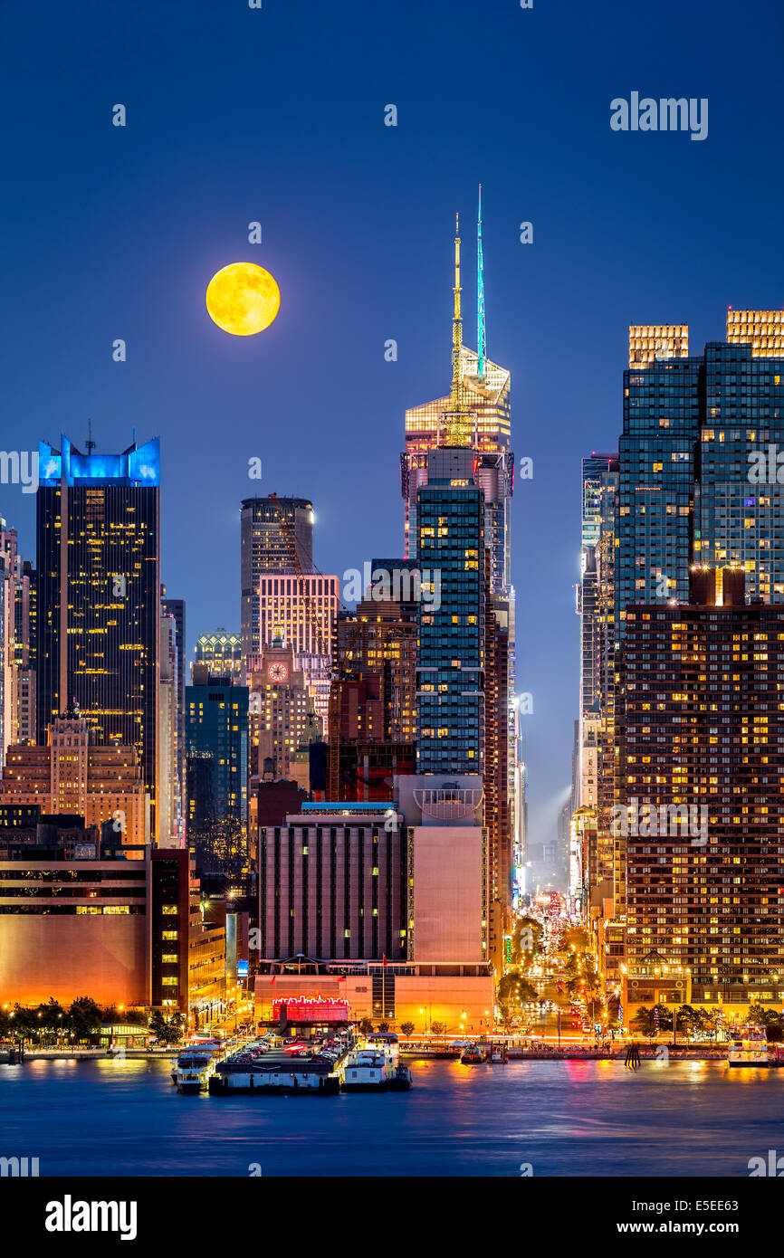 Super Luna salire al di sopra del centro di Manhattan grattacieli Foto Stock
