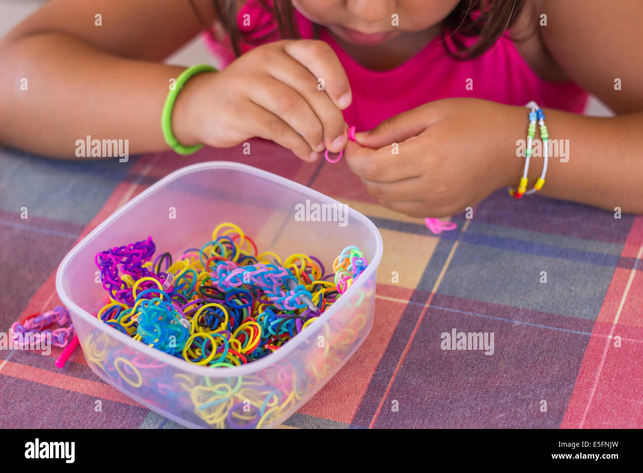 'Telaio bande' hobby contenitore molti colori variopinti mani rendendo bracciale bambino ragazza closeup Foto Stock