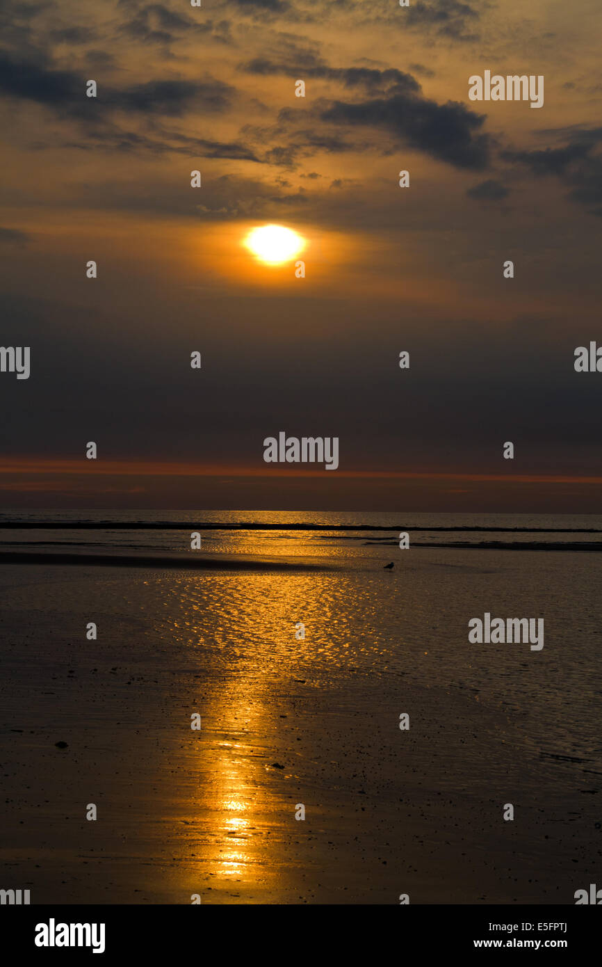 Tramonto sul mare, arancio e giallo le nuvole Foto Stock