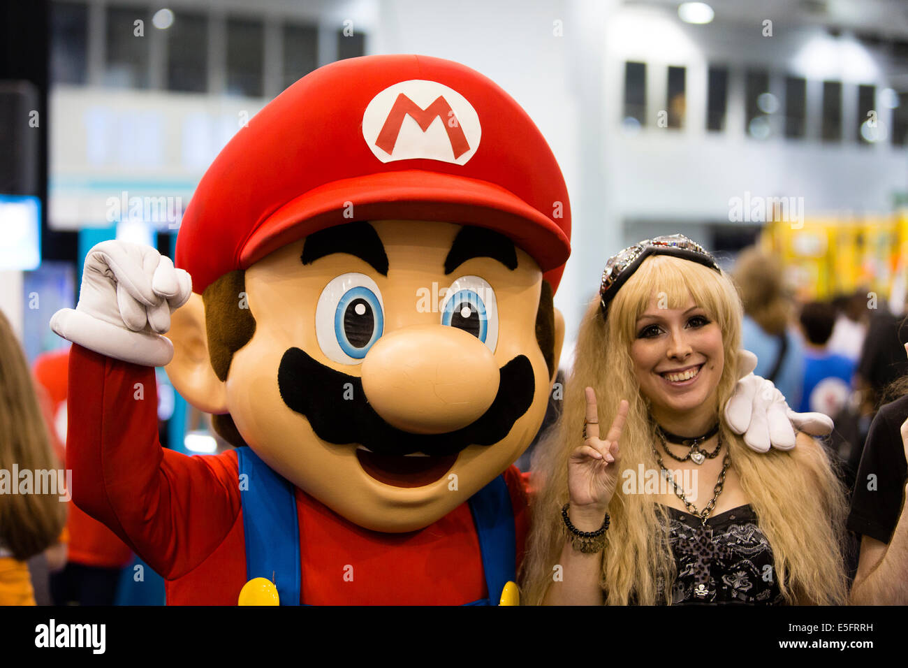 Londra, Inghilterra donna abbracciando Mario a Hyper Giappone in Earls Court. Foto Stock